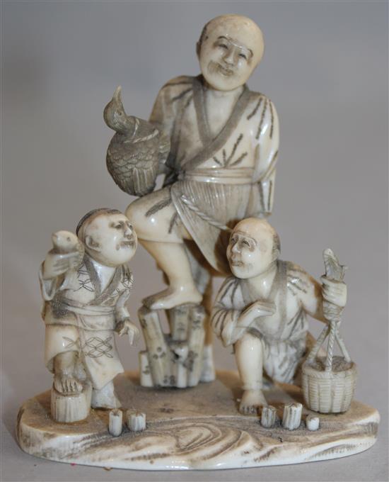 A Japanese carved ivory okimono group of street vendors, Meiji period,(-)